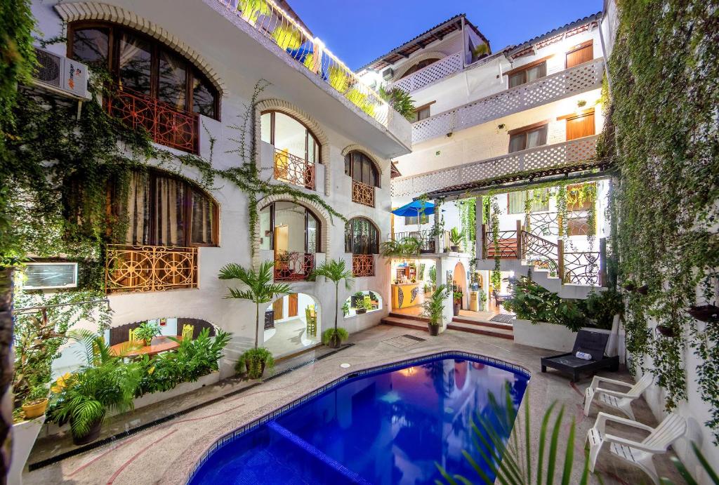 a courtyard with a swimming pool in a building at Hotel Hacienda de Vallarta Centro in Puerto Vallarta