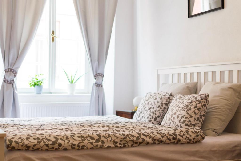 a bedroom with a bed with pillows and a window at B&B Krumlov in Český Krumlov