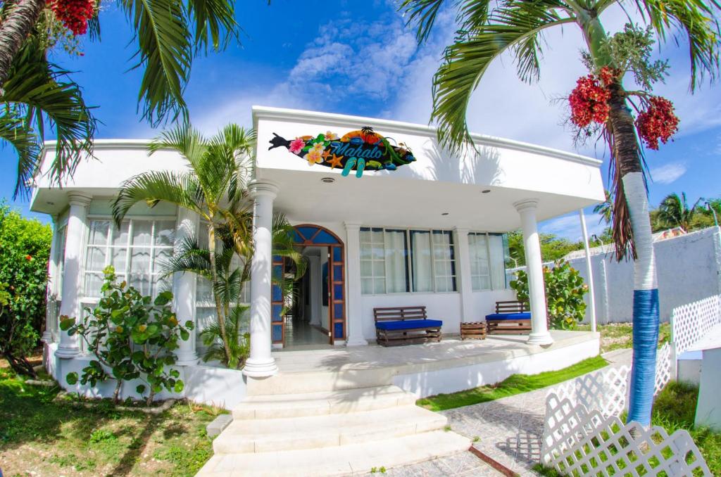 a white house with palm trees in front of it at MAHALO HOUSE B&B - Tu Casa Hospedaje en San Andrés Isla - in San Andrés