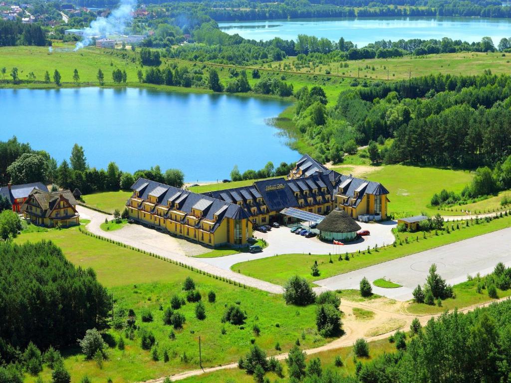 an aerial view of a resort with a lake at Manor Hotel in Olsztyn