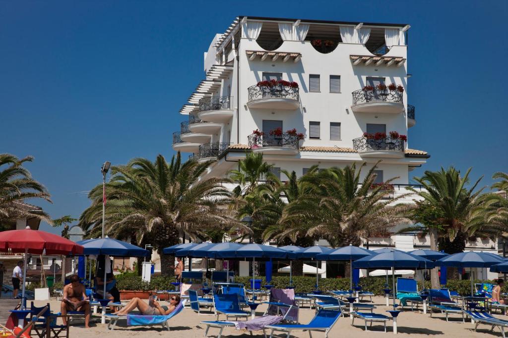 a hotel with lounge chairs and a roller coaster at Sympathy Hotel in Martinsicuro