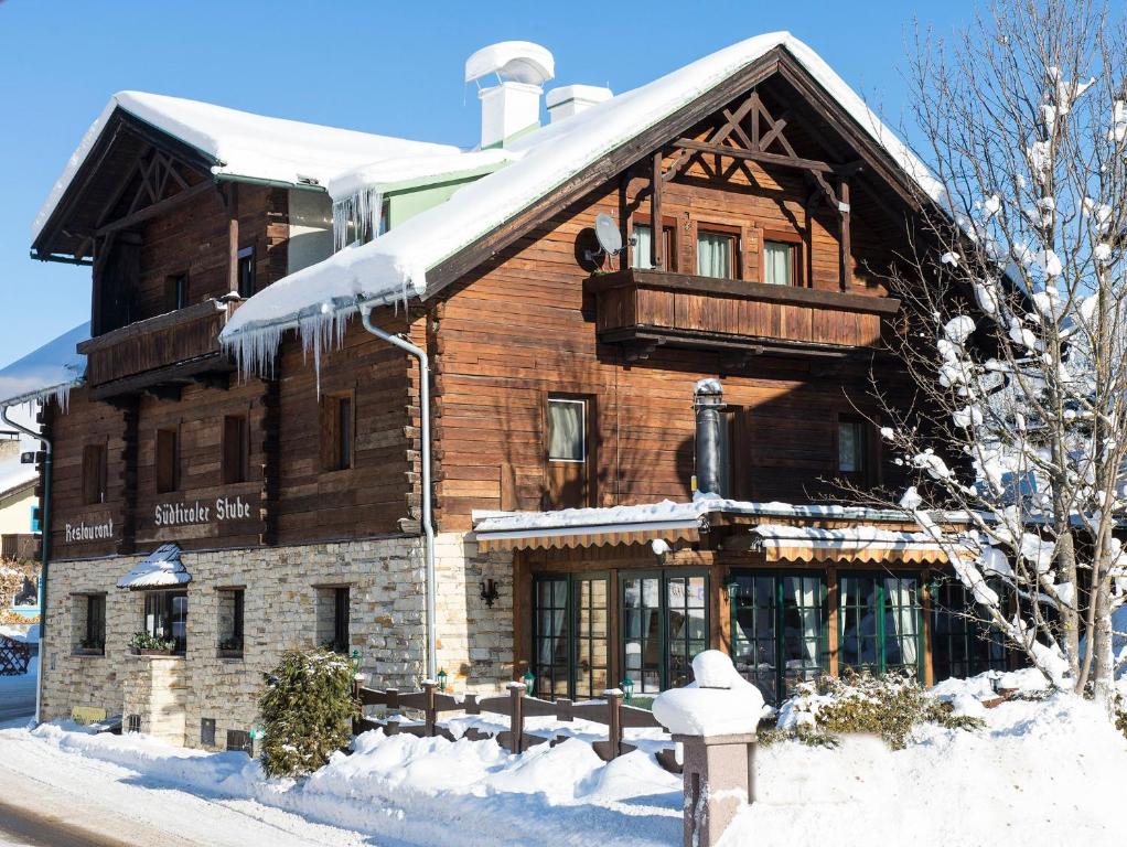 a large wooden building with snow on the ground at Südtiroler Stube in Seefeld in Tirol
