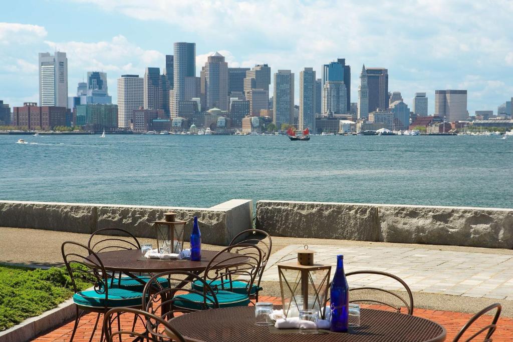 two tables and chairs with a view of the city at Hyatt Regency Boston Harbor in Boston
