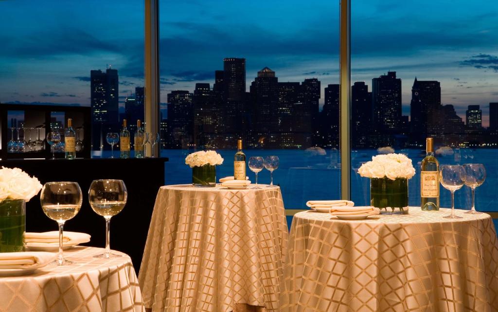 a couple of tables with wine glasses and flowers at Hyatt Regency Boston Harbor in Boston