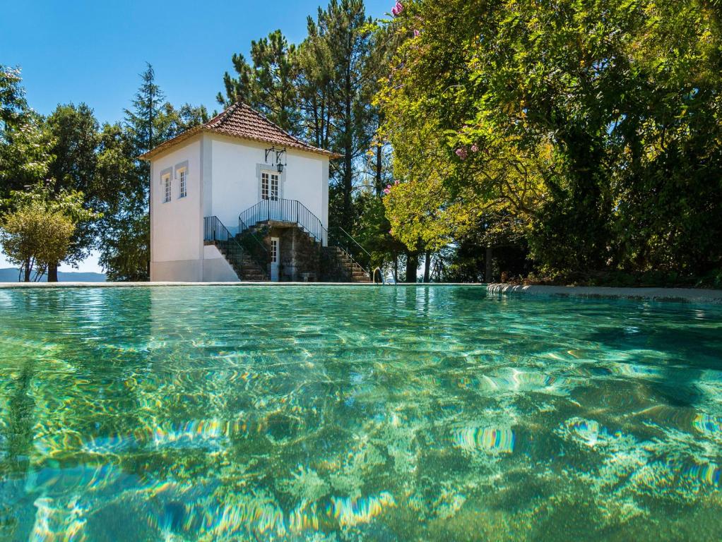 una piscina de agua con un edificio al fondo en Casas de Massinos, en Barroselas