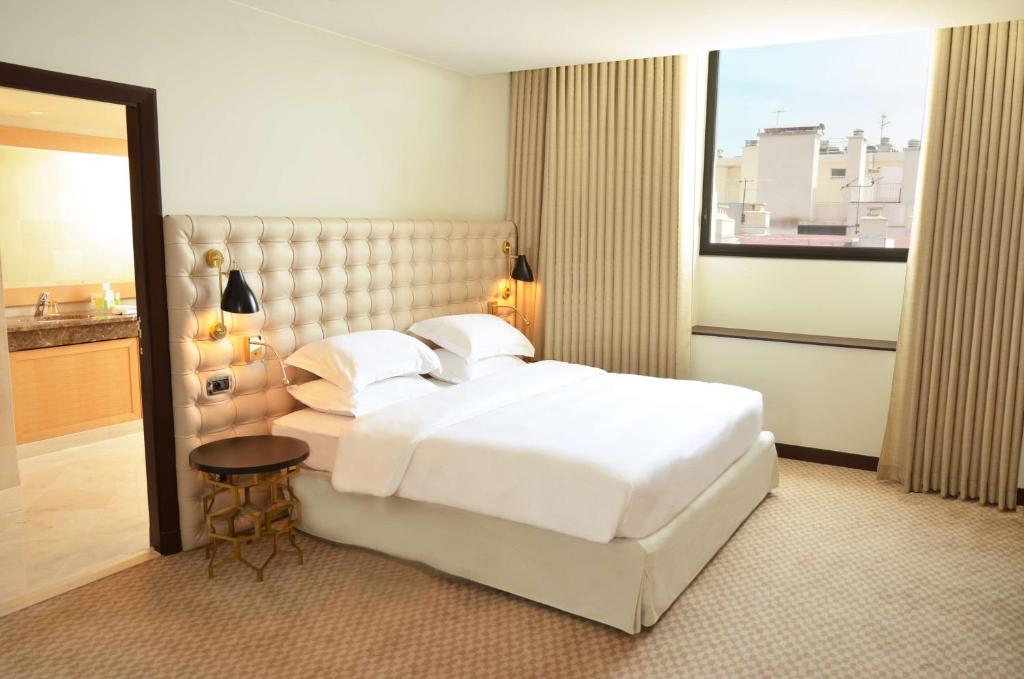 a bedroom with a large white bed and a window at Hyatt Regency Nice Palais de la Méditerranée in Nice