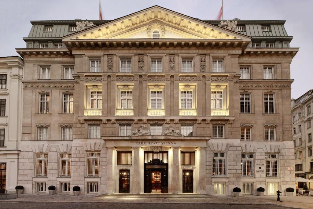 a large building in a city with lights on at Park Hyatt Vienna in Vienna