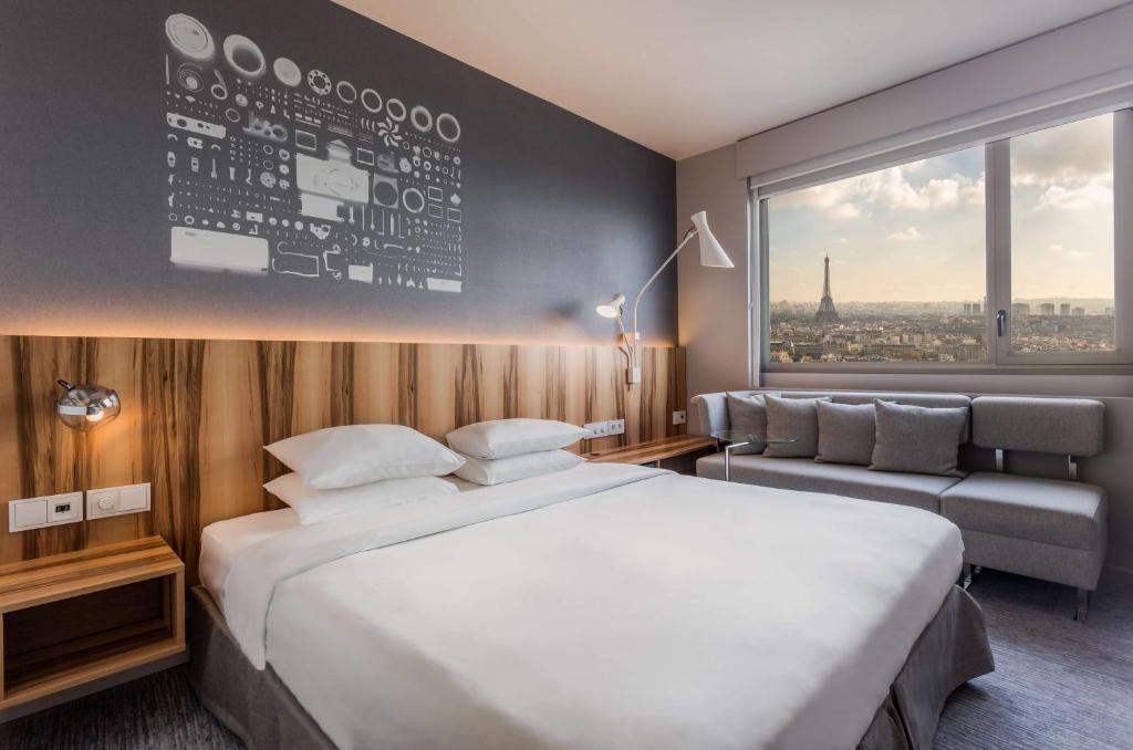 a hotel room with a large bed and a large window at Hyatt Regency Paris Etoile in Paris