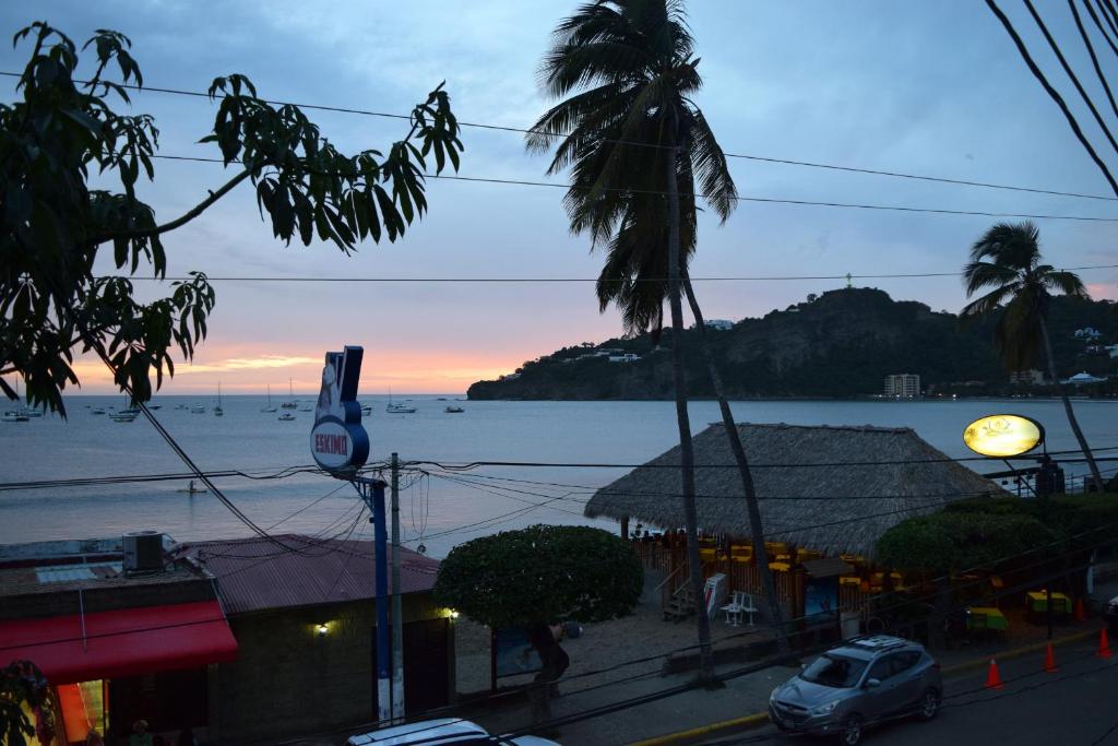 a view of a street with a building and the ocean at Beachfront Condo El Torreón San Juan del Sur in San Juan del Sur