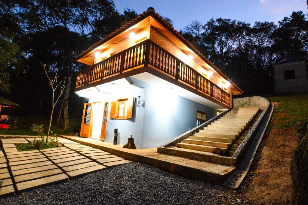 a small house with stairs and lights on it at Pousada Bruxa Marela in Monte Verde