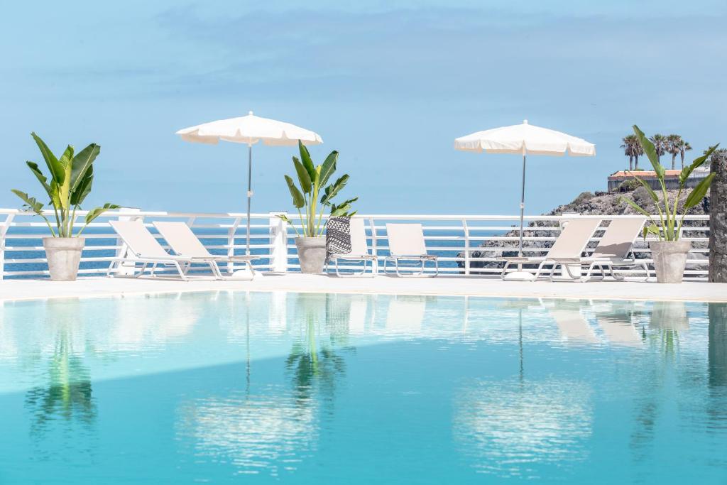 een zwembad met stoelen en parasols op een strand bij Atlantic Holiday Hotel in Callao Salvaje