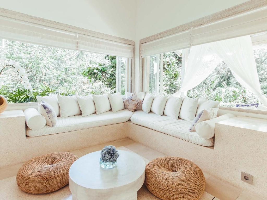 un soggiorno con divano bianco e finestra di Cloud Nine Estate ad Ubud
