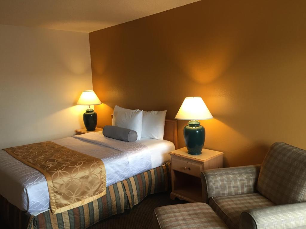 Habitación de hotel con cama y silla en Tiki Lodge en Medford