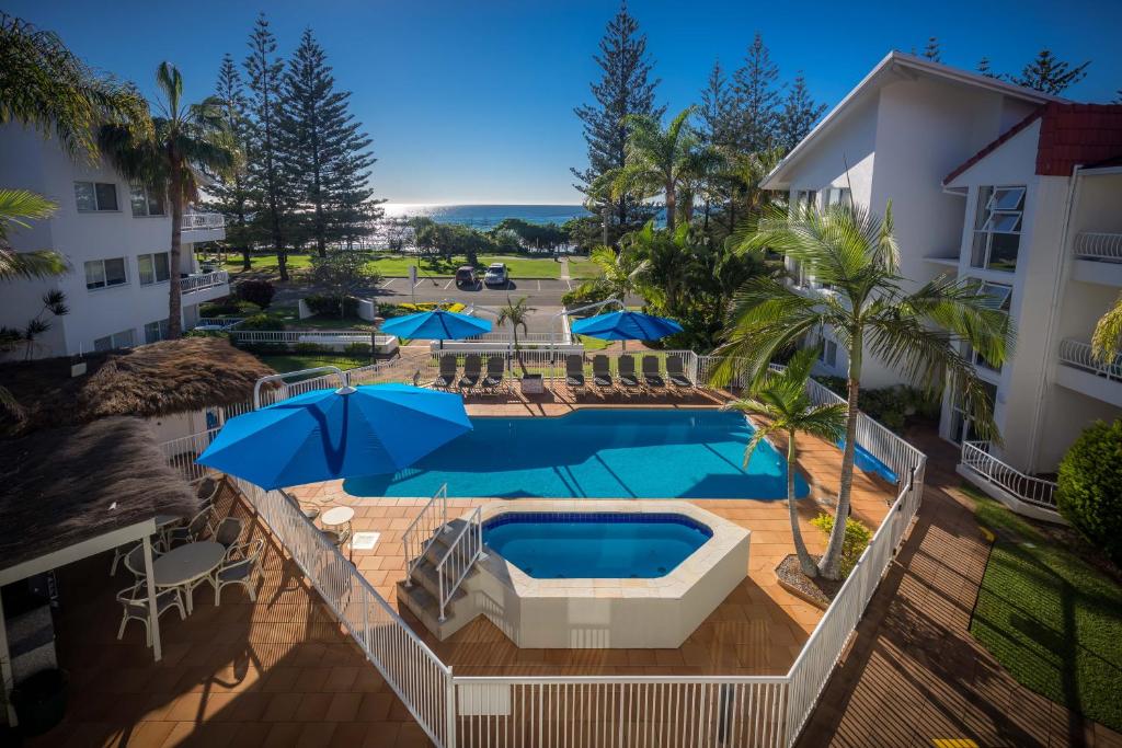 an overhead view of a swimming pool with umbrellas at Le Beach Apartments in Gold Coast