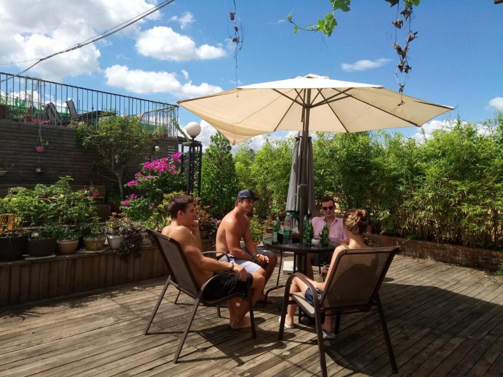 a group of people sitting at a table under an umbrella at Sky Garden Inn in Guilin