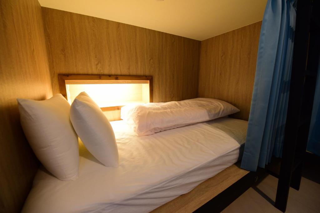 台東市的住宿－二高輕旅 K2 Hostel ，一间卧室配有带枕头和灯的床