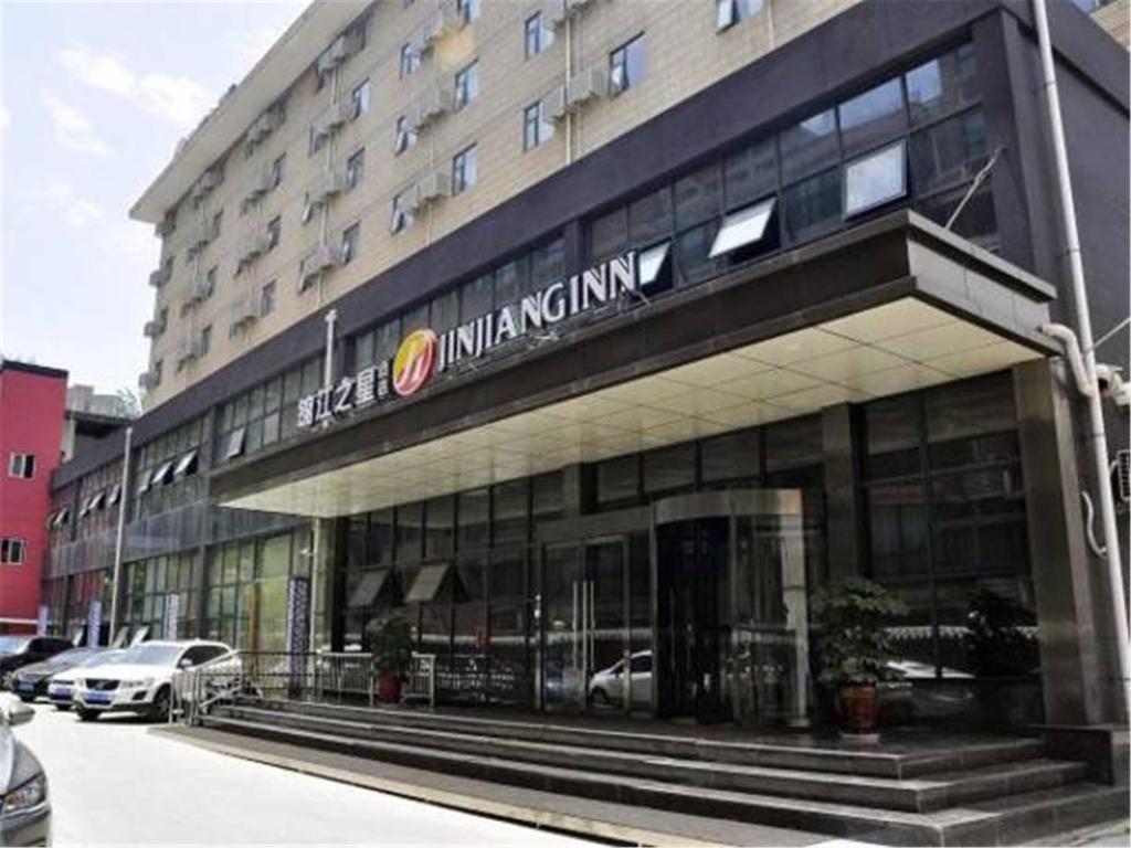 a large building with a sign on the front of it at Jinjiang Inn Select XiAn East 2nd Ring Jiangong Road in Xi'an