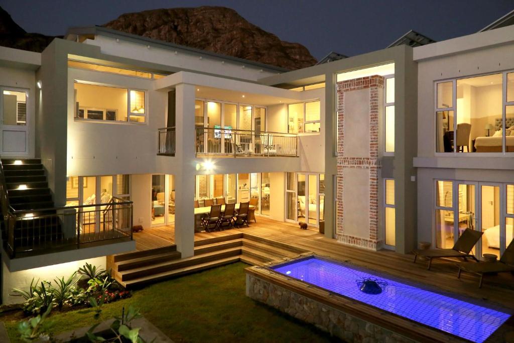 a villa with a swimming pool at night at Cape Coral in Hermanus