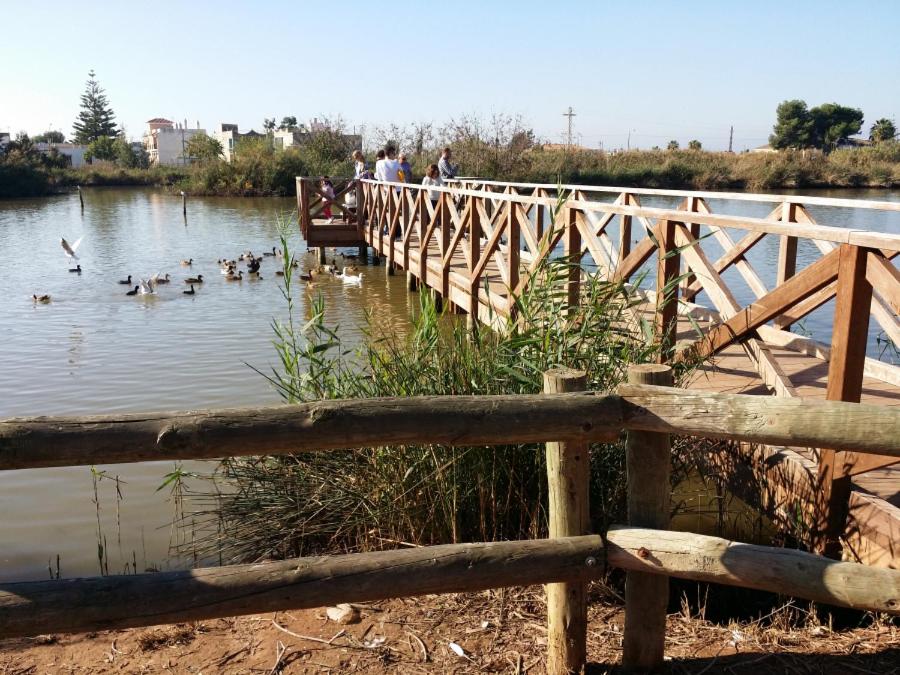 un puente de madera sobre un cuerpo de agua con patos en Apartamento Nules Experience en Mascarell