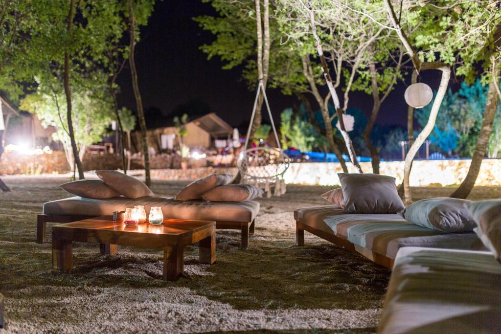 Boutique Camping Nono Ban في Gornji Humac: مجموعة من الأرائك جالسة في الفناء في الليل