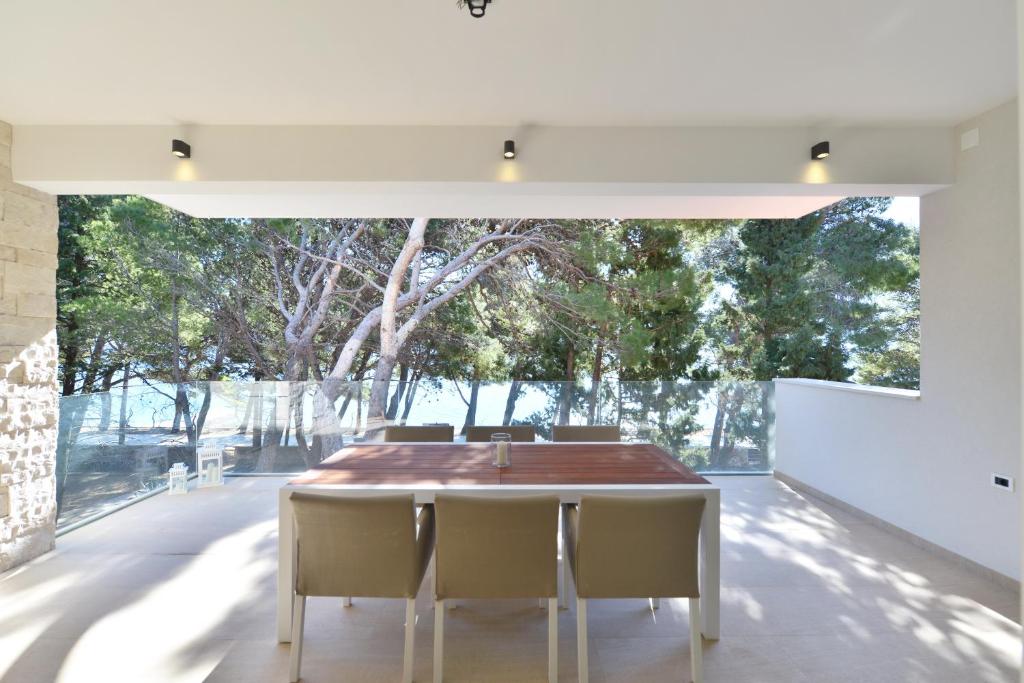 a dining room with a table and chairs and a large window at Chiponsky One - 5 star beachfront property in Bol