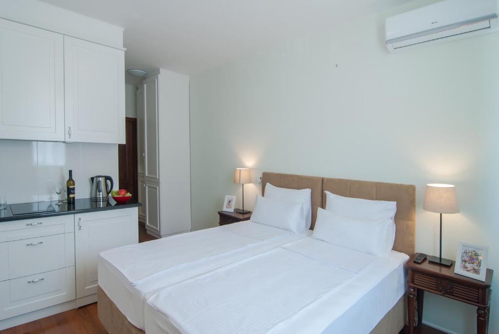 a bedroom with a large white bed with white cabinets at Vila Opera in Vrnjačka Banja
