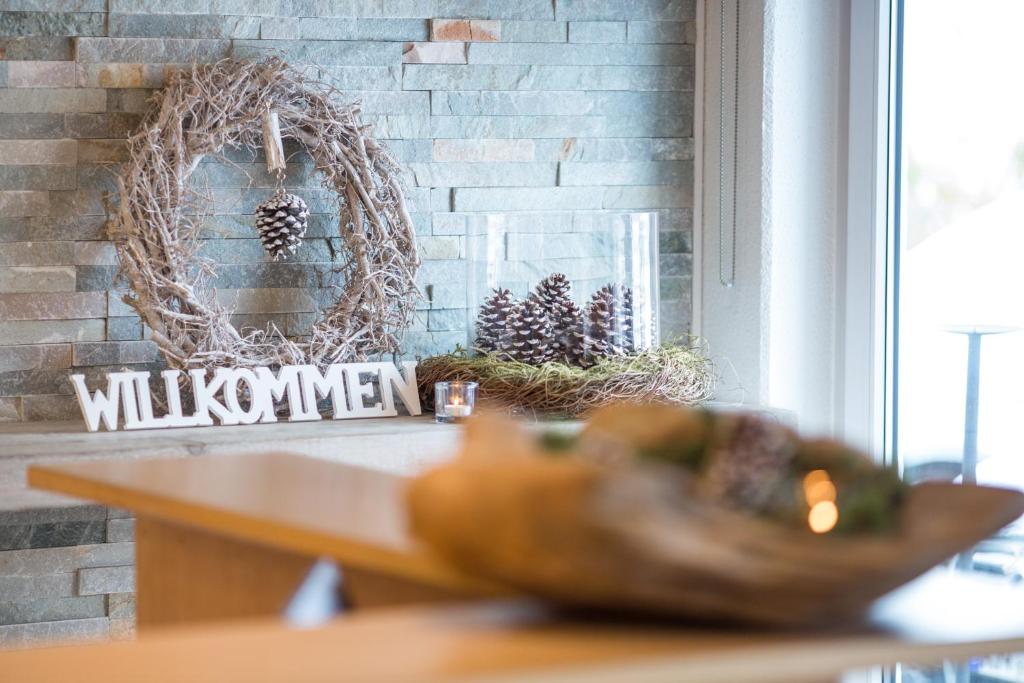 une couronne suspendue sur un mur de briques avec une table dans l'établissement Hotel Restaurant Am Kellhof, à Singen