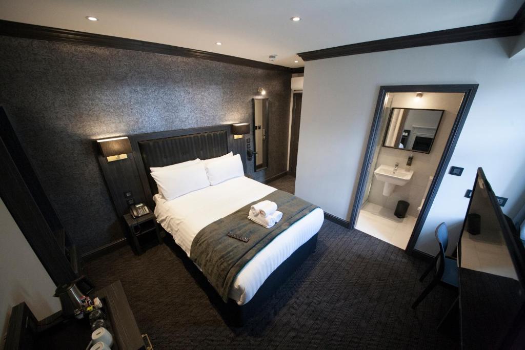 a hotel room with a bed and a bathroom at The Duke Rooms London in London