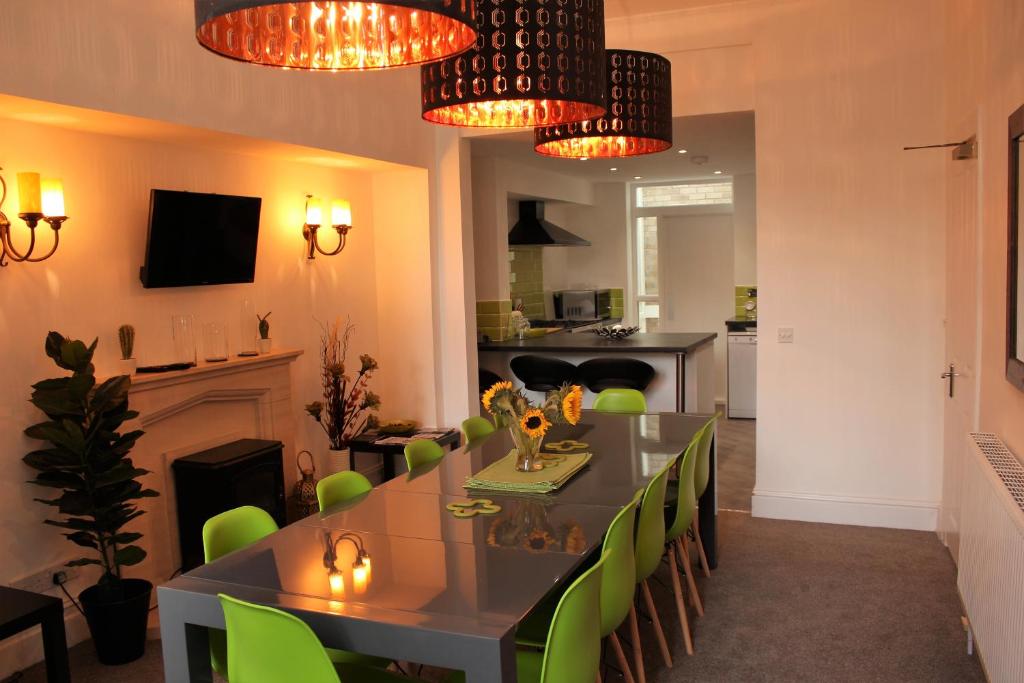 a dining room with a table and green chairs at Sea-Esta in Weymouth