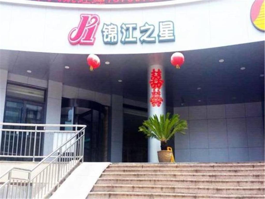 un edificio con una planta delante en Jinjiang Inn Qingdao Cangkou Park en Qingdao