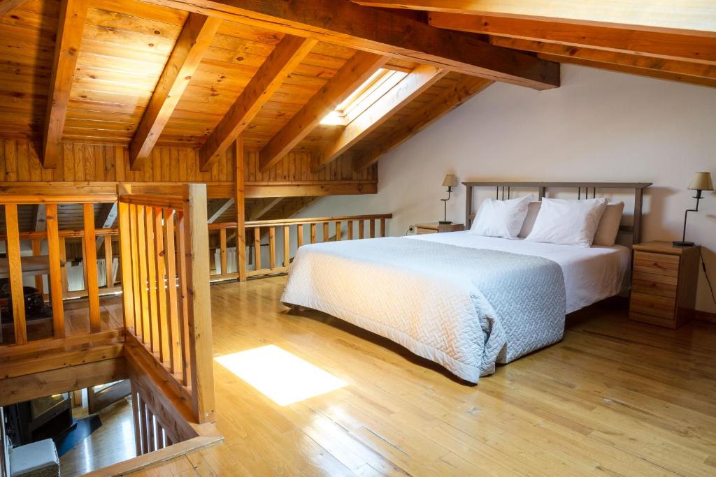 アルプにあるla Cabana dels Isardsの木製の天井が特徴のベッドルーム1室(大型ベッド1台付)