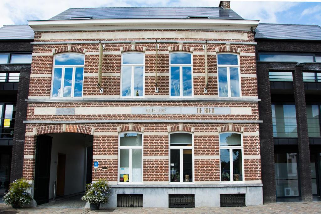 a red brick building with blue windows on it at Hostellerie De Biek in Moorsel