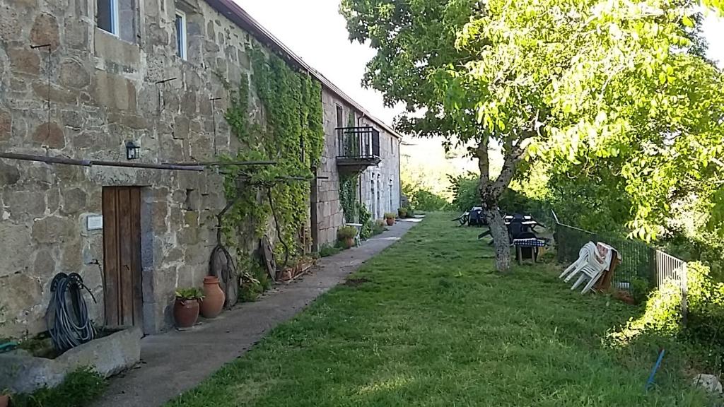 a building with a grass yard next to a building at Casa do Comediante in Cerdeira