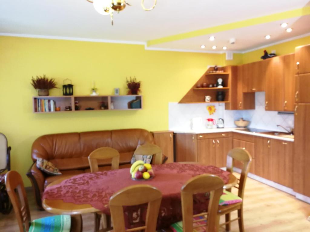 eine Küche und ein Esszimmer mit einem Tisch und einem Sofa in der Unterkunft Apartament Barbara in Szczyrk