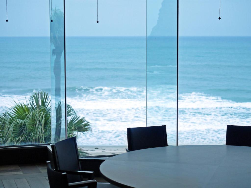 stół i krzesła z widokiem na ocean w obiekcie Tanegashima Iwasaki Hotel w Minamitane