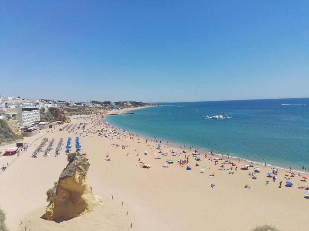 a beach with a lot of people and the ocean at Casa da Praia in Albufeira