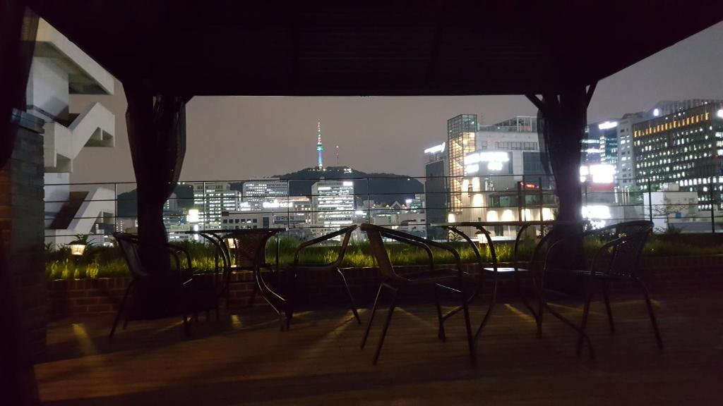 a group of chairs sitting on a balcony at night at Grid Inn Hotel in Seoul