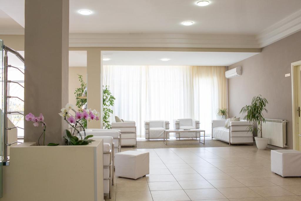 a waiting room with white chairs and tables at Hotel Holiday in Vasto