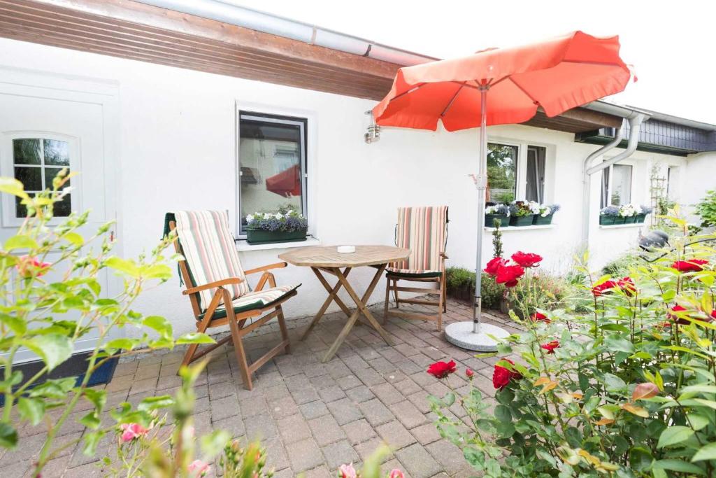 a patio with a table and chairs and an umbrella at Ferienwohnungen in ruhiger Ortsran in Lauterbach