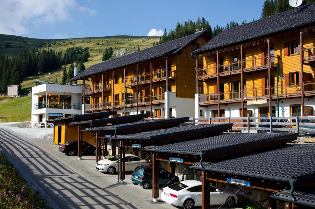 a group of buildings with cars parked in a parking lot at Sissi Park in Lachtal