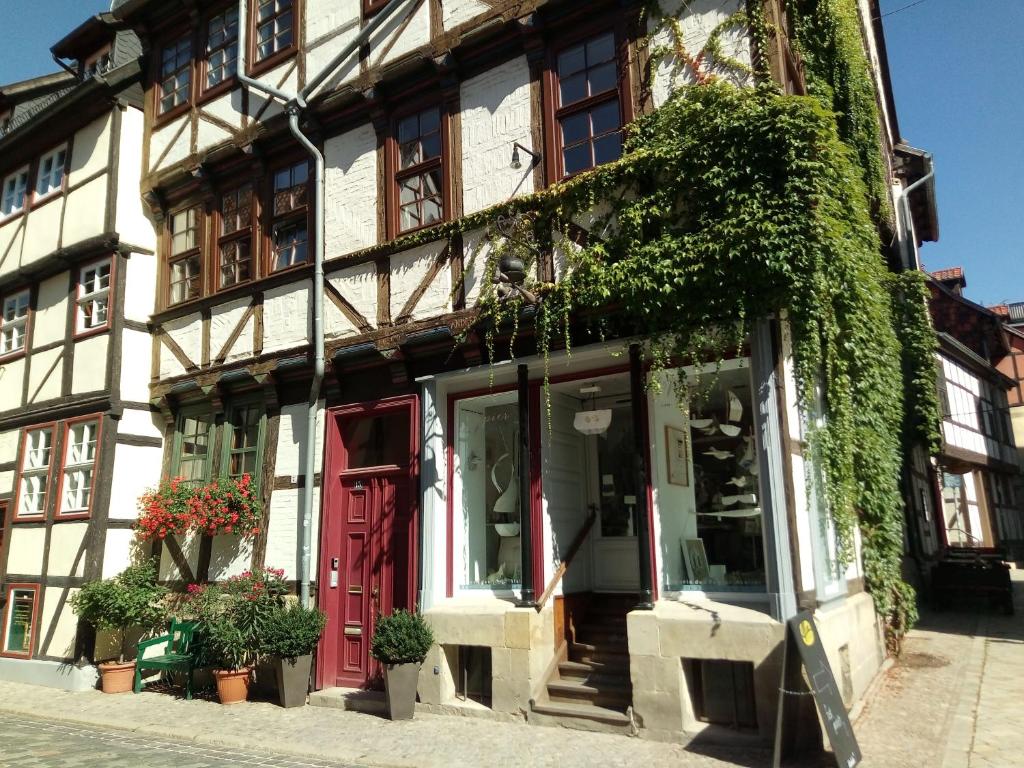 un edificio con una puerta roja y hiedra en Ferienwohnungen Marktstrasse 15 en Quedlinburg