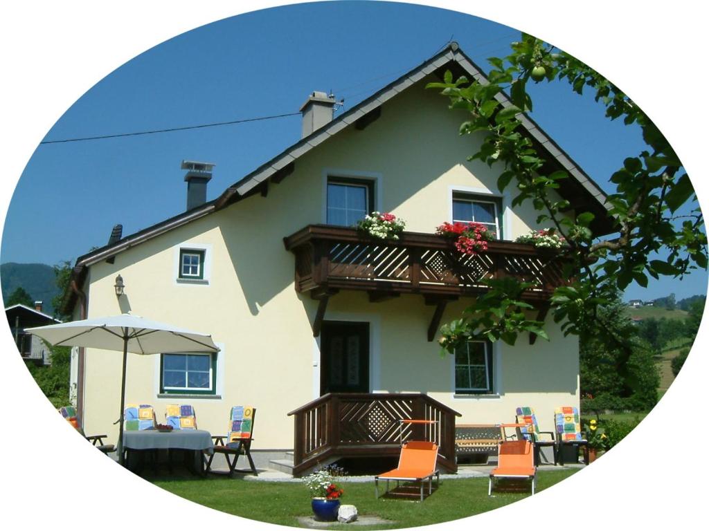 a house with a balcony and a table and chairs at Ferienhaus Humer in Altmünster