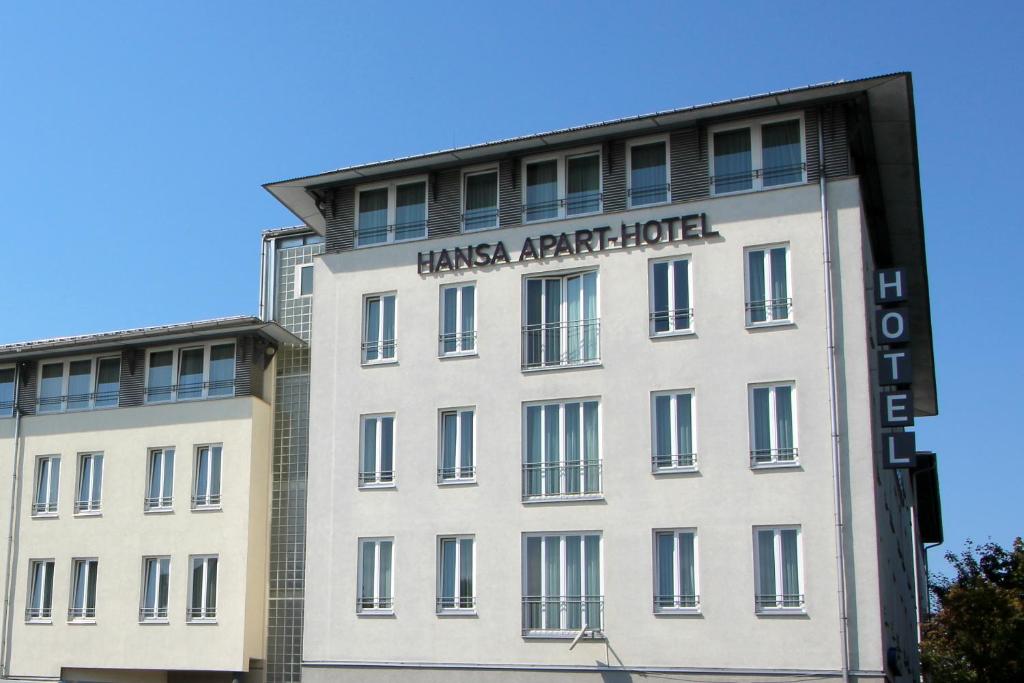 ein großes weißes Gebäude mit einem Schild drauf in der Unterkunft Hansa Apart-Hotel Regensburg in Regensburg