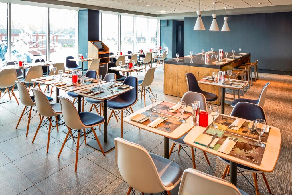 a restaurant with tables and chairs and a bar at ibis London Elstree Borehamwood in Borehamwood