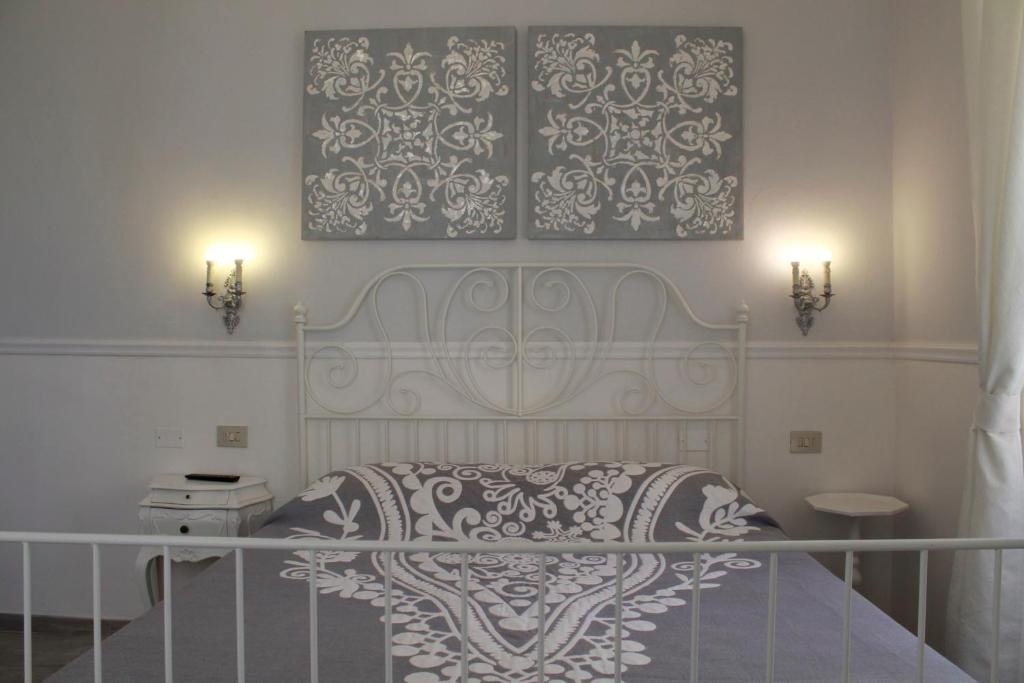 ラ・スペツィアにあるAppartamento Golfo della Luna 2のベッドルーム1室(ベッド1台付)が備わります。壁に2枚の写真が飾られています。