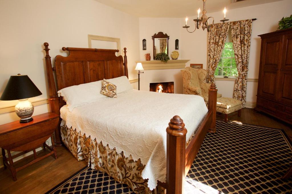 sypialnia z dużym łóżkiem i kominkiem w obiekcie The Zevely Inn w mieście Winston-Salem