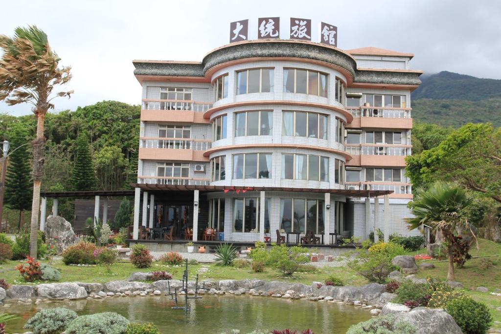 a large building with a pond in front of it at Da-Tong Vacation Hotel in Chenggong