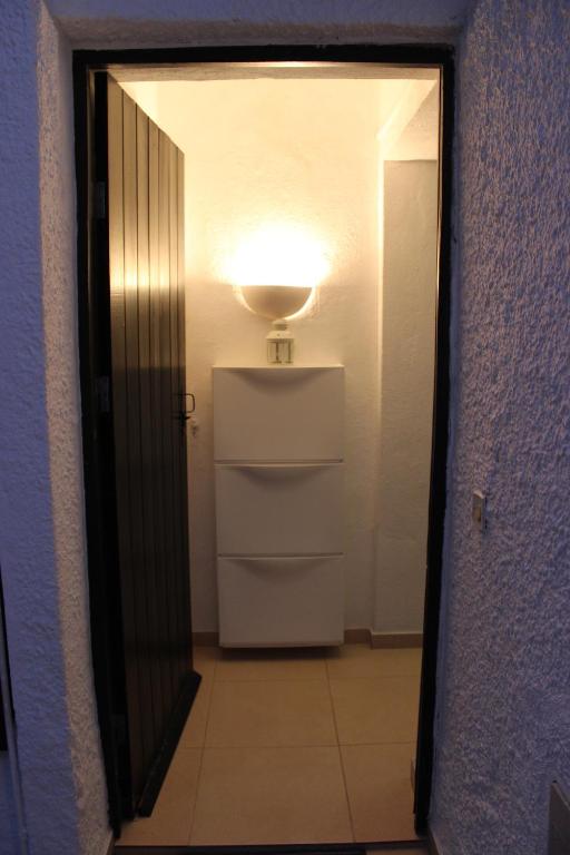 a room with a door with a light and a refrigerator at Pedras Del Rei Studio in Tavira