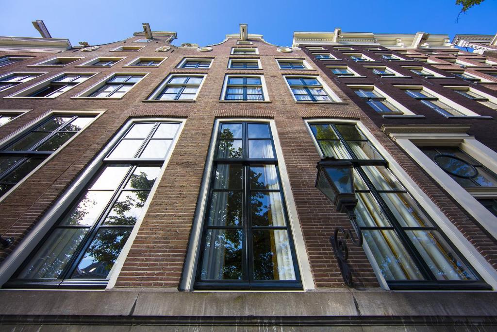 un edificio de ladrillo alto con muchas ventanas. en Dutch Masters Short Stay Apartments, en Ámsterdam