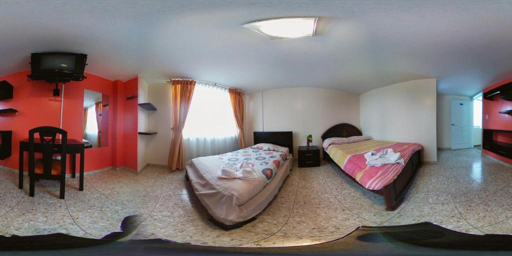 Postel nebo postele na pokoji v ubytování Hostal La Rosa Otavalo
